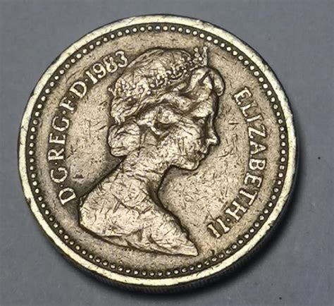 design by Timothy Noad of The Floral emblems of England the Rose and the Oak arching towards <strong>one</strong> another accompanied by the inscription. . Decus et tutamen one pound coin value